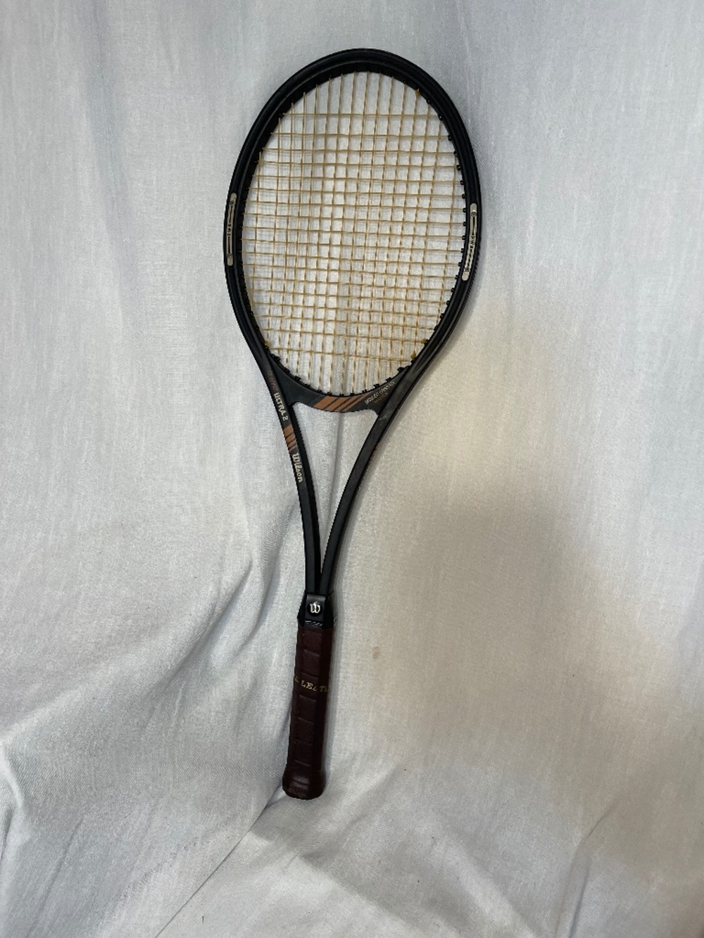 Wilson Black Tennis Racket with Brown Grip and Tan Strings